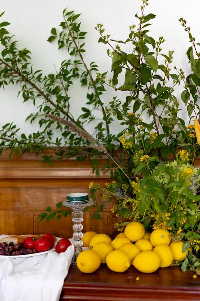 Ağaç dallarıyla süslenmiş bir sandık dolusu çekmece, üzerinde domatesli, zeytinli ve limonlu bir tabak yiyecek yatıyor. Yüksek kalite fotoğraf