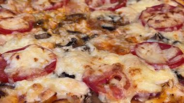 Pizza, yakından yaklaştığında, fırından yeni çıkarıldığında, kaynama süreci durmaz. Yüksek kaliteli FullHD görüntüler