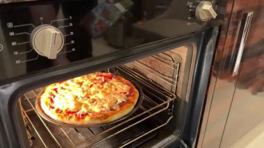 Benzin istasyonundaki fırında pişmiş pizzayı götüren bir adamın eli. Yüksek kaliteli FullHD görüntüler