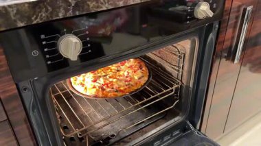 Benzin istasyonundaki fırında pişmiş pizzayı götüren bir adamın eli. Yüksek kaliteli FullHD görüntüler