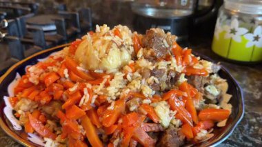 Özbekistan 'dan geleneksel Plov yemeği. Ana yemek genellikle pirinç, et parçaları, havuç ve soğan ile yapılır. Yüksek kaliteli FullHD görüntüler