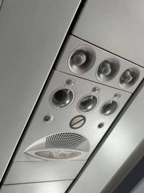Havalandırma delikleri, okuma ışıkları ve çağrı düğmeleri dahil bir uçağın tepe paneli. Yüksek kalite fotoğraf