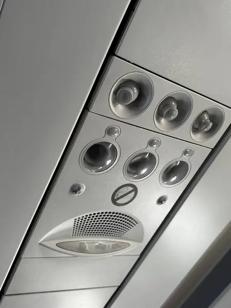 Havalandırma delikleri, okuma ışıkları ve çağrı düğmeleri dahil bir uçağın tepe paneli. Yüksek kalite fotoğraf