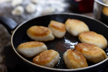 Mutfakta kızgın yağlı tavada patates turtası pişiriyoruz. Yüksek kalite fotoğraf