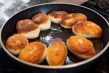 Mutfakta kızgın yağlı tavada patates turtası pişiriyoruz. Yüksek kalite fotoğraf