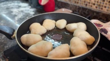 Kızartma tavasında kızgın yağda pişirilmiş patates ve mantarlı Rus turtaları. Yüksek kaliteli FullHD görüntüler