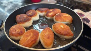 Kızartma tavasında kızgın yağda pişirilmiş patates ve mantarlı Rus turtaları. Yüksek kaliteli FullHD görüntüler