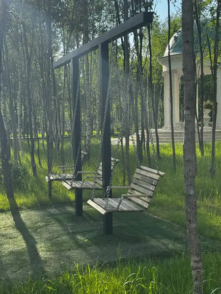 Parkta sallanan boş ahşap salıncakların yan görüntüsü yumuşak, yalnız ahşap salıncak konsepti. Yüksek kaliteli FullHD görüntüler