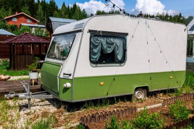 Bahçedeki antika bir karavan mahremiyet ve romantizm için rahat bir dinlenme yeri oluşturuyor. Yüksek kalite fotoğraf