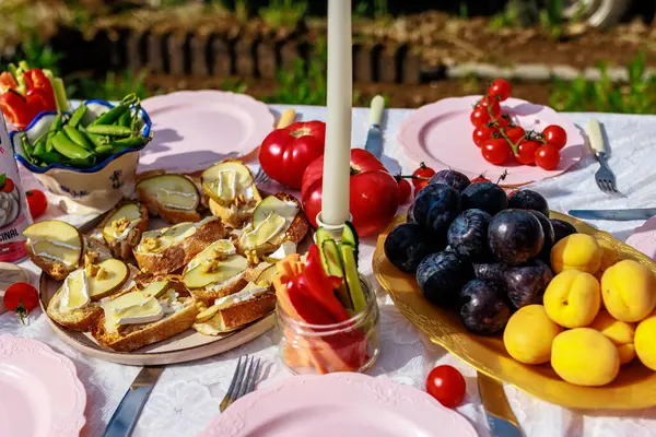 Bir tabak armut ve peynirli bruschetta, meyve kasesi ve güzel dekore edilmiş domateslerle süslenmiş aperatifler. Yüksek kalite fotoğraf