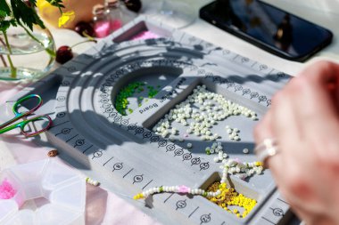 Hobi kavramı. Sanatsal kadın ellerinin boncuklu bilezik yaratması. Yüksek kalite fotoğraf