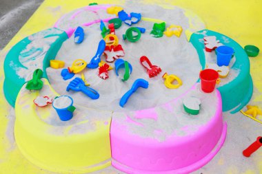 Çocuklar dışarıda kum havuzunda çeşitli aletler, aletler ve oyuncaklar var. Yüksek kalite fotoğraf