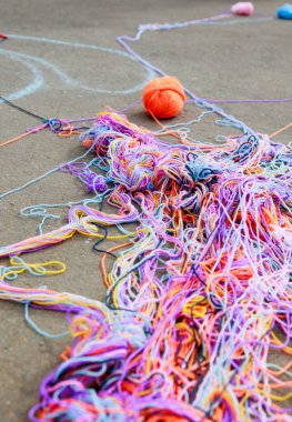 Bir iletişim oyunundan sonra asfalt üzerinde çok renkli örgü ipliklerinden oluşan karışık bir ağ uzanır. Yüksek kalite fotoğraf