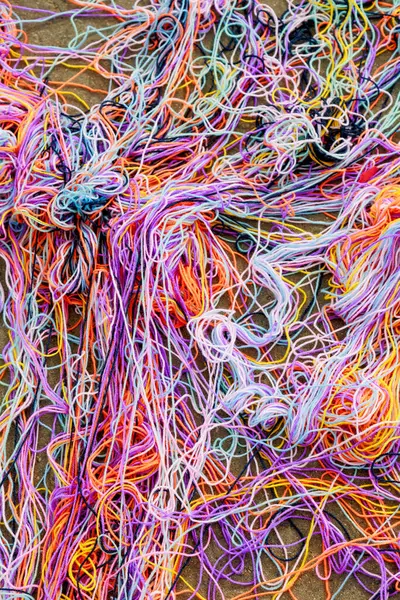 Bir iletişim oyunundan sonra asfalt üzerinde çok renkli örgü ipliklerinden oluşan karışık bir ağ uzanır. Yüksek kalite fotoğraf