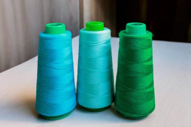 Renkli yeşil ve turkuaz terziler ahşap arka planda yakın plan iplikleri. Yüksek kalite fotoğraf