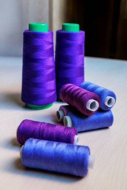 Ahşap arka planda renkli mor ve mavi terzilik iplikleri. Yüksek kalite fotoğraf