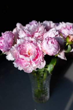 Parlak güneş ışığında cam bir vazoda güzel şakayıklar. Yüksek kalite fotoğraf