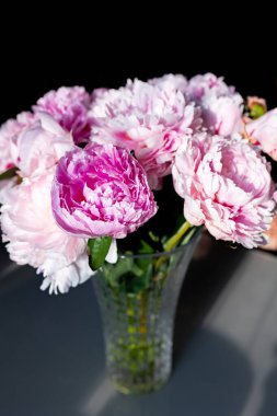 Parlak güneş ışığında cam bir vazoda güzel şakayıklar. Yüksek kalite fotoğraf