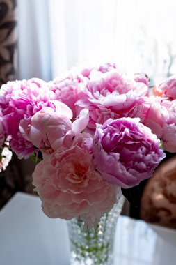 Parlak güneş ışığında cam bir vazoda güzel şakayıklar. Yüksek kalite fotoğraf