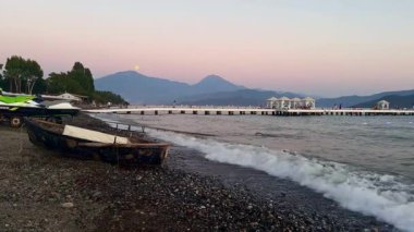 Akdeniz 'in karanlık ve sakin yüzeyinde altın gün batımı gökyüzü. Gün batımına karşı ağır çekimde hareket eden resim gibi dalgalar. Yüksek kaliteli FullHD görüntüler