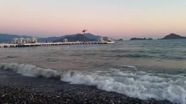 Akdeniz 'in karanlık ve sakin yüzeyinde altın gün batımı gökyüzü. Gün batımına karşı ağır çekimde hareket eden resim gibi dalgalar. Yüksek kaliteli FullHD görüntüler