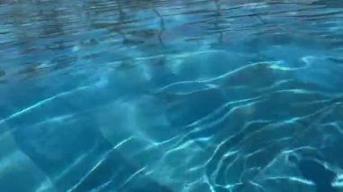 Yüzme havuzu su kristal berraklığında, ışık yüzeyden yansıyor. Yüksek kaliteli FullHD görüntüler