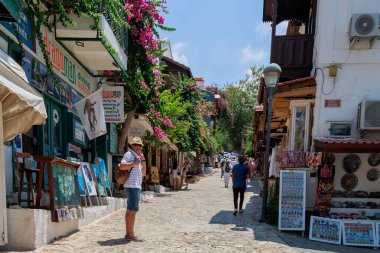  Kas, Türkiye - 10 Temmuz 2025: Turistler çok sayıda dükkan ve kafe ile çevrili Kas kentindeki bir yaya caddesinde yürüyüp fotoğraf çekiyorlar. Yüksek kalite fotoğraf