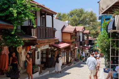  Kas, Türkiye - 10 Temmuz 2025: Turistler çok sayıda dükkan ve kafe ile çevrili Kas kentindeki bir yaya caddesinde yürüyüp fotoğraf çekiyorlar. Yüksek kalite fotoğraf