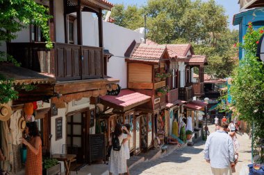  Kas, Türkiye - 10 Temmuz 2025: Turistler çok sayıda dükkan ve kafe ile çevrili Kas kentindeki bir yaya caddesinde yürüyüp fotoğraf çekiyorlar. Yüksek kalite fotoğraf