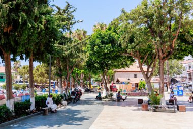 Kas, Türkiye 10 Temmuz 2025: İnsanlar marinanın yanındaki meydanda, çok sayıda kafe ve turist dükkanıyla çevrili şekilde oturuyorlar. Yüksek kalite fotoğraf