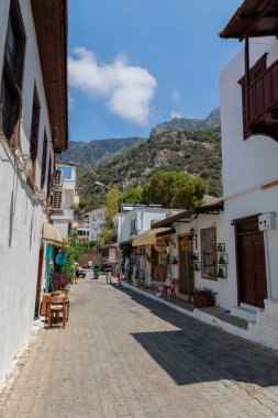  Kas, Türkiye - 10 Temmuz 2025: Turistler çok sayıda dükkan ve kafe ile çevrili Kas kentindeki bir yaya caddesinde yürüyüp fotoğraf çekiyorlar. Yüksek kalite fotoğraf