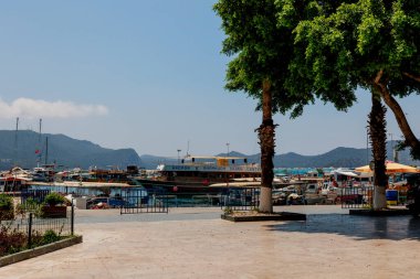 Kas, Türkiye - 10 Temmuz 2025: Türkiye 'nin Kas kentinde yürüyüş için bir turist reklamı ile liman manzarası. Yüksek kalite fotoğraf