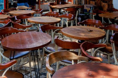 Türkiye 'nin Kas kentindeki bir açık kafeye ahşap retro masalar ve sandalyeler sıkıca yerleştirildi. Yüksek kalite fotoğraf