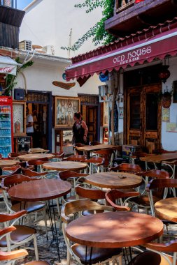 Türkiye 'nin Kas kentindeki bir açık kafeye ahşap retro masalar ve sandalyeler sıkıca yerleştirildi. Yüksek kalite fotoğraf