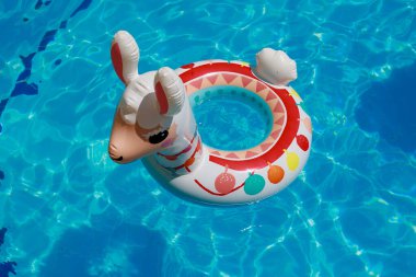 Şişme lama şekilli yüzme topu havuzda yüzüyor. Lama şeklin güzelmiş. Yüksek kalite fotoğraf