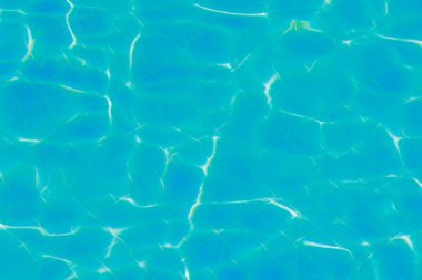 Yüzeyinde dalgalanmalar olan mavi su. Odaklanmamış, bulanık, şeffaf, mavi, temiz, sakin su yüzeyi dokusu. Parlak desenli su dalgaları, arka plan dokusu. Yüksek kalite fotoğraf