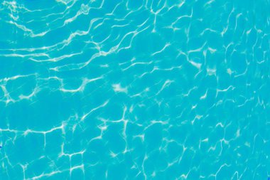 Yüzeyinde dalgalanmalar olan mavi su. Odaklanmamış, bulanık, şeffaf, mavi, temiz, sakin su yüzeyi dokusu. Parlak desenli su dalgaları, arka plan dokusu. Yüksek kalite fotoğraf