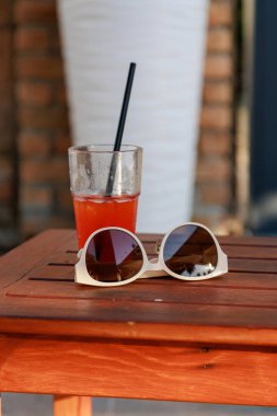 Havuzun yanındaki masada nefis bir kokteylin olduğu bir bardağın yakın çekimi, güneş gözlükleri yakınlarda duruyor. Tatilde yaz içkileri. Dinlen ve rahatla. Yüksek kalite fotoğraf