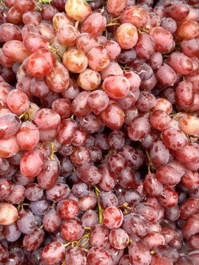 Koyu bir zemin üzerinde olgun kırmızı üzümler ve böğürtlenlerin üzerine su damlaları, yakın plan. Yüksek kalite fotoğraf