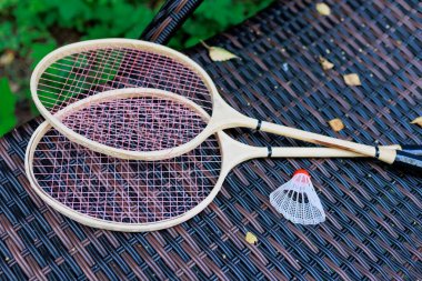 Beyaz badminton topu ve iki raket parktaki bir şezlongda yatıyor. Boş zaman, eğlence, raket sporları. Yüksek kalite fotoğraf