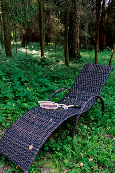 Beyaz badminton topu ve iki raket parktaki bir şezlongda yatıyor. Boş zaman, eğlence, raket sporları. Yüksek kalite fotoğraf