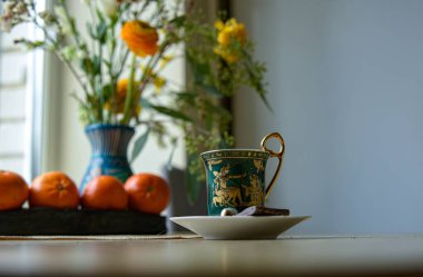 Masada çiçekler ve çaydanlıkla kahve molası.