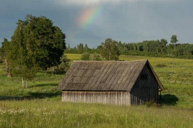 Kırsal kesimdeki eski bir evin üzerinde gökkuşağı