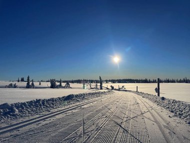 Norveç 'in Sjusjoen kentinde, parlak bir güneşin altında, geniş bir karla kaplı bir araziyle çevrili, yeni hazırlanmış İskandinav kayak pistleri.