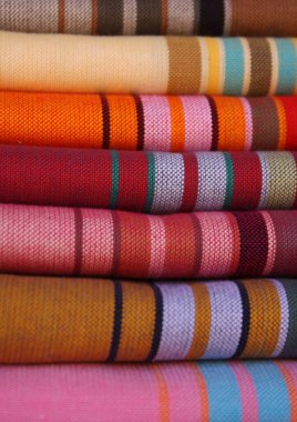 Renkli dokuma kumaşlar, canlı çizgili desenler, geleneksel zanaatkarlık ve tekstil sanatları. Parlak ve karmaşık tasarımlar moda veya dekor için idealdir.