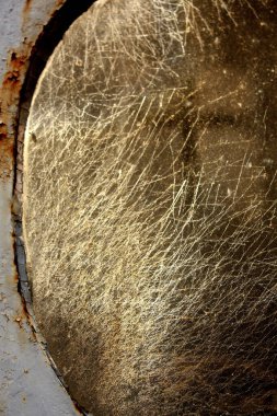 Yuvarlak çerçeveli, yıpranmış, metal bir yüzeye yakın çekim, boya soyma, ve Buenos Aires 'teki La Recoleta Mezarlığı' nda çekilmiş bir haçın soluk yansıması.