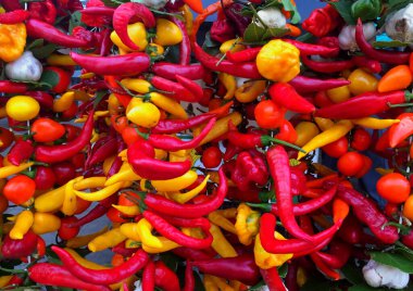 İspanya 'nın Mallorca kentindeki yerel bir cadde pazarında sarımsakla sarımsak serpiştirilmiş renkli kırmızı biberlerden oluşan canlı bir çeşitlilik.