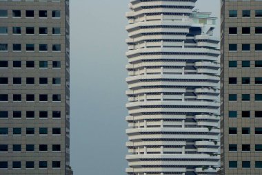 Urban cityscape with modern skyscrapers in Singapore, featuring geometric building facades and a clear skyline in the background, highlighting the city's architectural design clipart