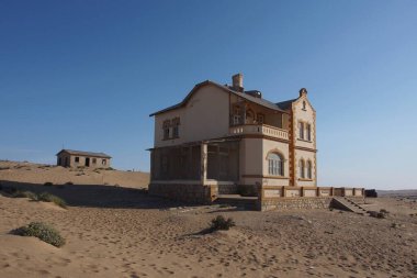 Kolmanskop, Namibya - 13 Eylül 2019: Luderitz 'in dışındaki hayalet şehir Kolmanskop' ta terk edilmiş binalar, bir zamanlar gelişen elmas madenciliği yerleşkesi, şimdi Namib Çölleri tarafından ele geçirildi.