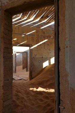 Kolmanskop, Namibya - 13 Eylül 2019: Luderitz 'in dışındaki hayalet şehir Kolmanskop' ta terk edilmiş binalar, bir zamanlar gelişen elmas madenciliği yerleşkesi, şimdi Namib Çölleri tarafından ele geçirildi.